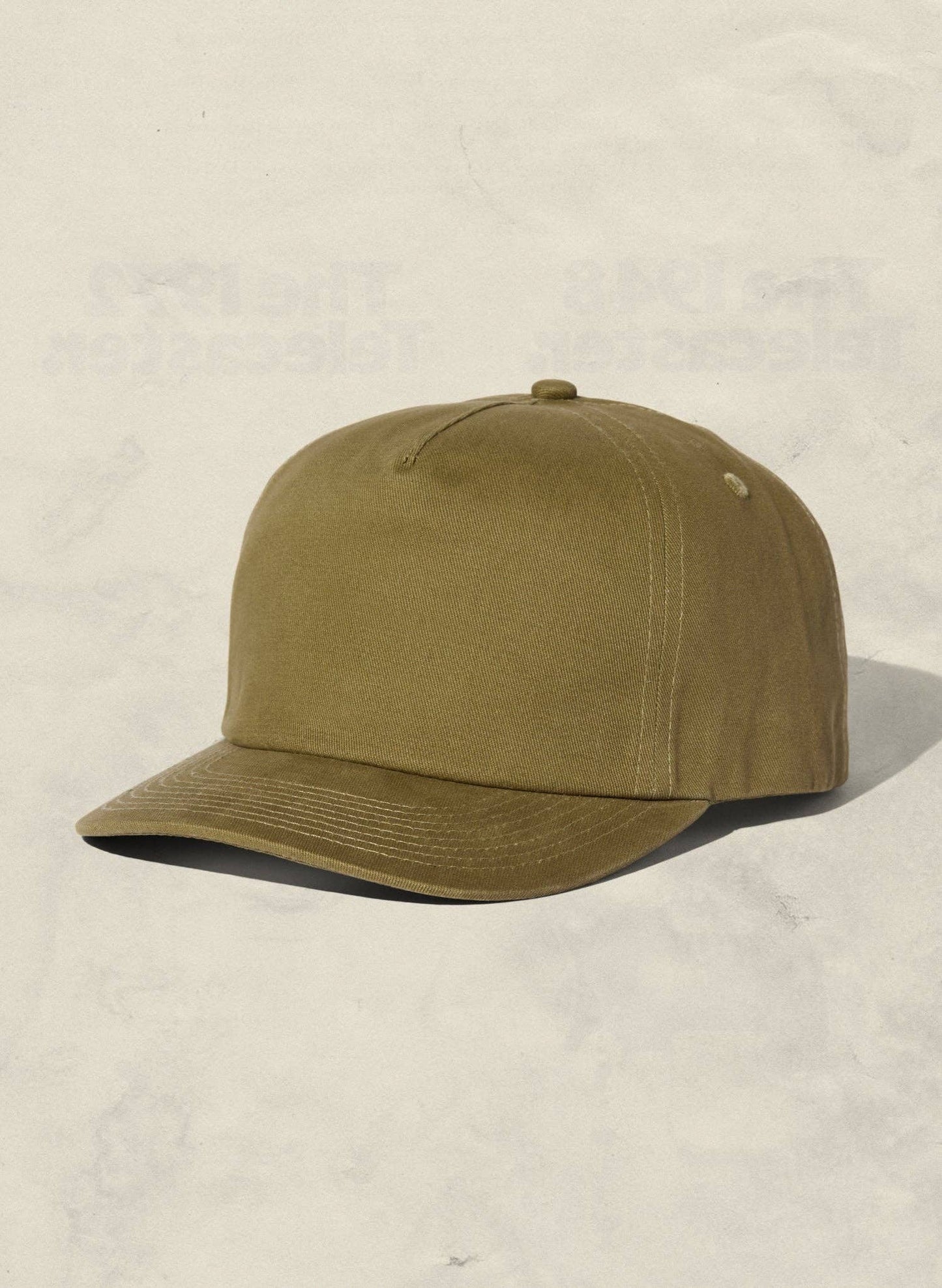 Olive green cap on a beige background