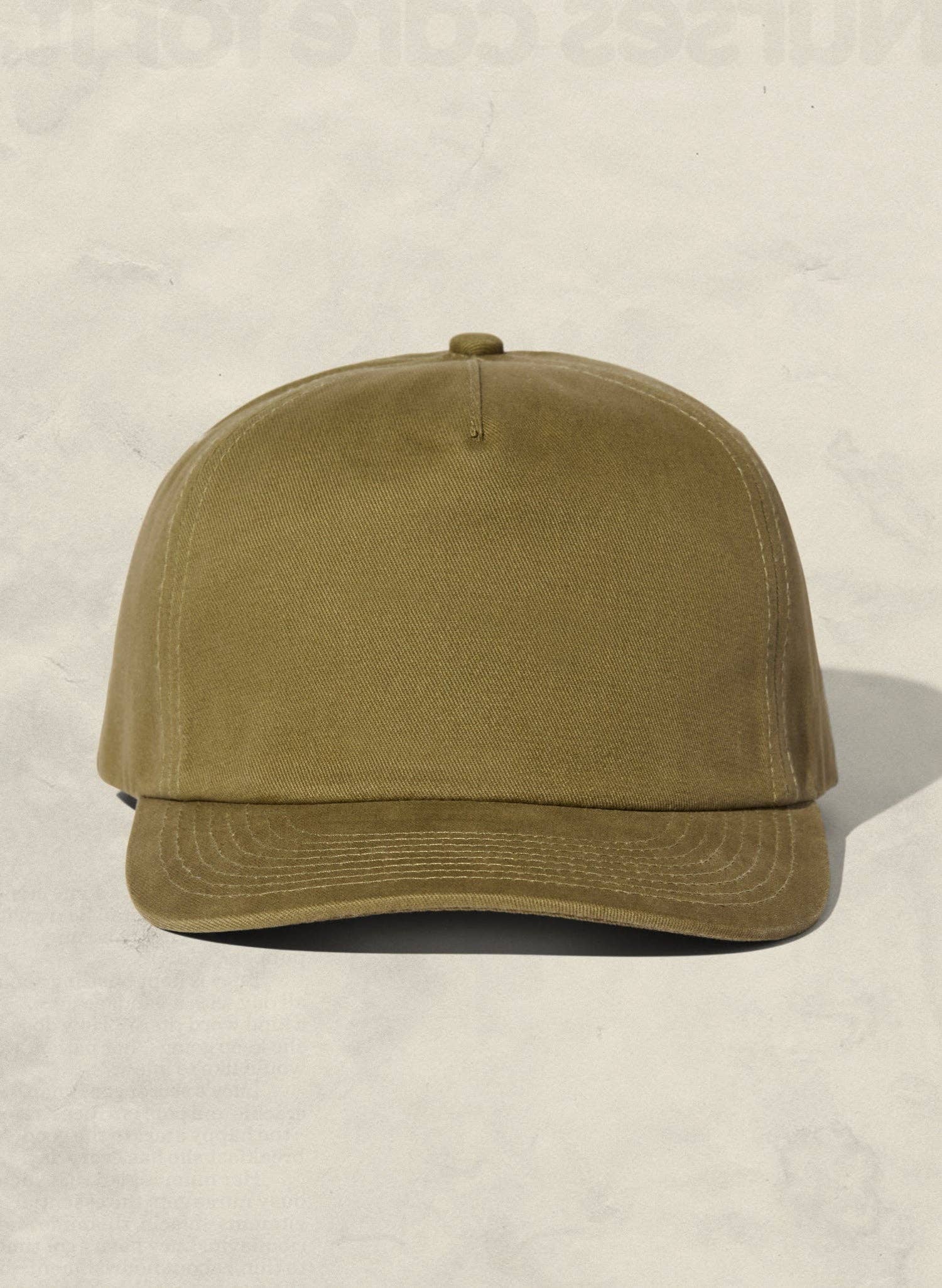 Olive green baseball cap on a beige background