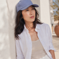 Woman wearing a light blue cap and white shirt outdoors