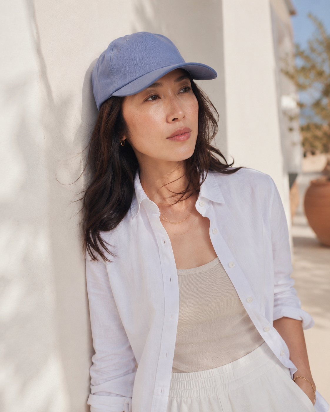 Woman wearing a light blue cap and white shirt outdoors