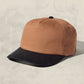 Brown and black cap on a beige background