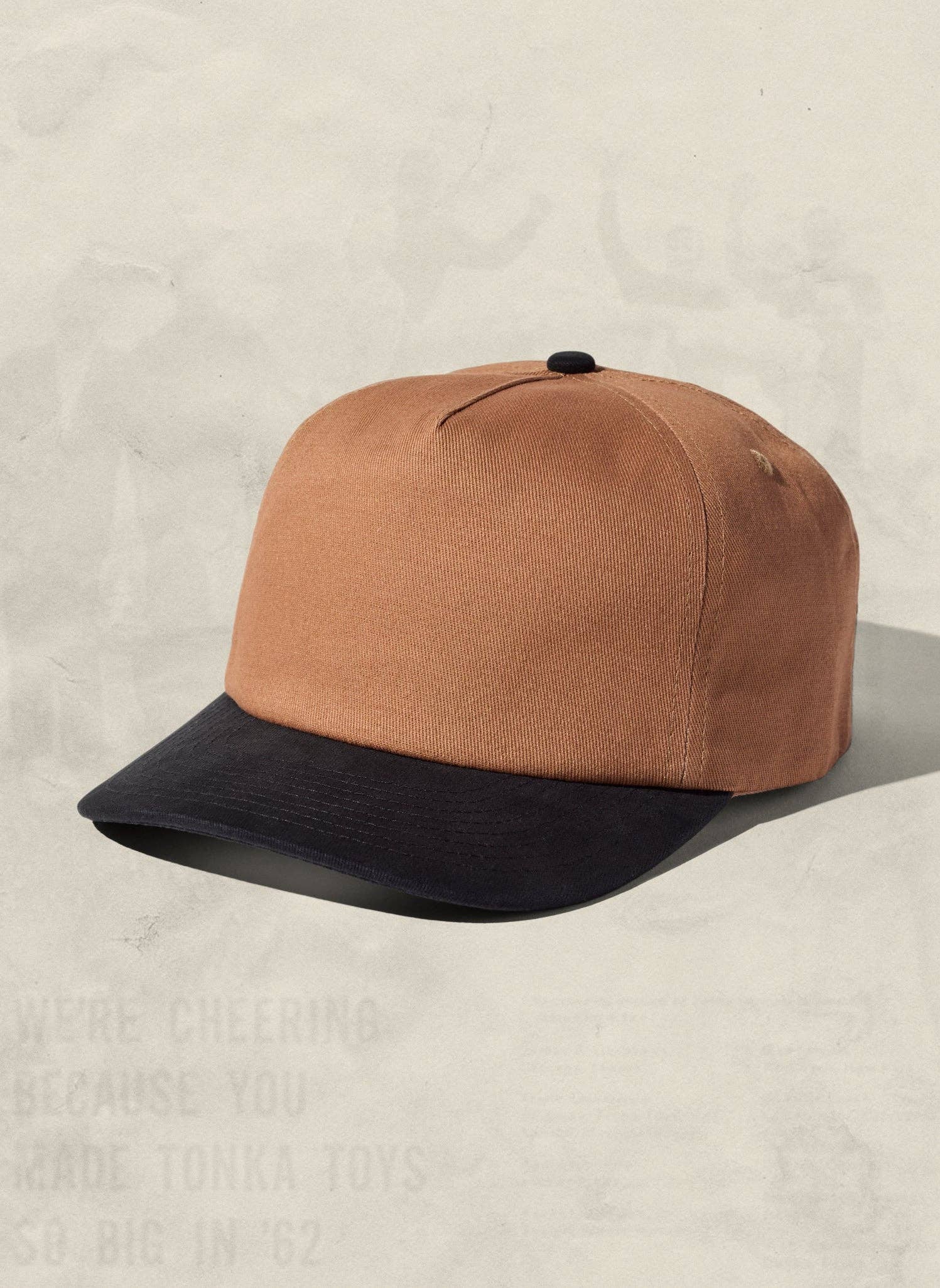 Brown and black cap on a beige background