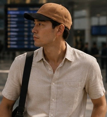 Man wearing a beige cap and light-colored shirt in an airport setting