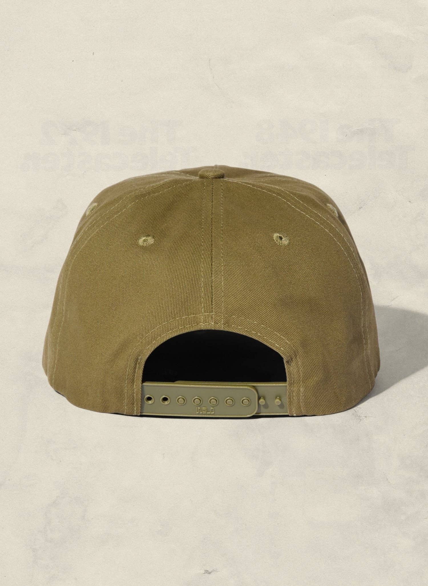 Olive green cap on a light beige background