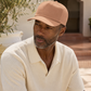 Man wearing a beige cap and polo shirt outdoors