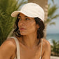Woman wearing a white cap with a blurred natural background