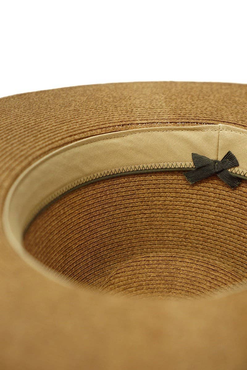 Close-up of a brown straw hat with a black ribbon on a white background