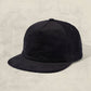 Black cap on a textured beige background