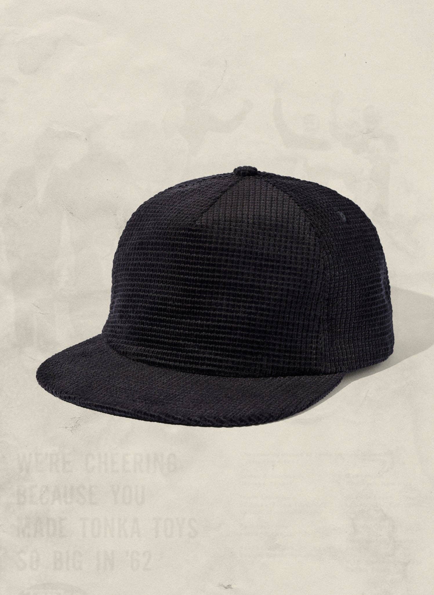 Black cap on a textured beige background