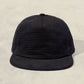 Black textured cap on a beige background