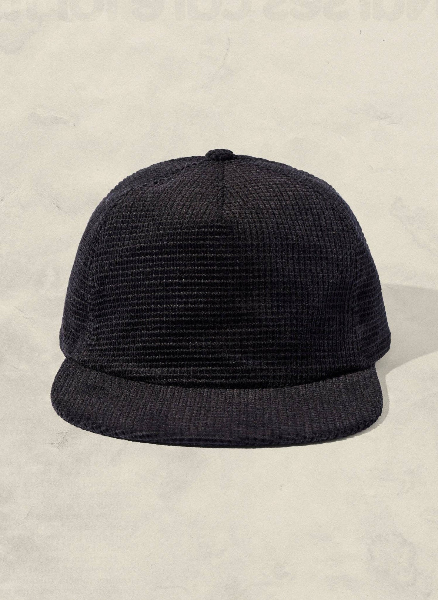 Black textured cap on a beige background